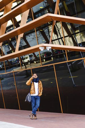Stylish guy using smartphone outside modern building