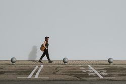 Woman with bag walking along parking lot
