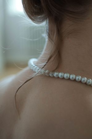 Close-up shot of back of woman wearing pearl necklace