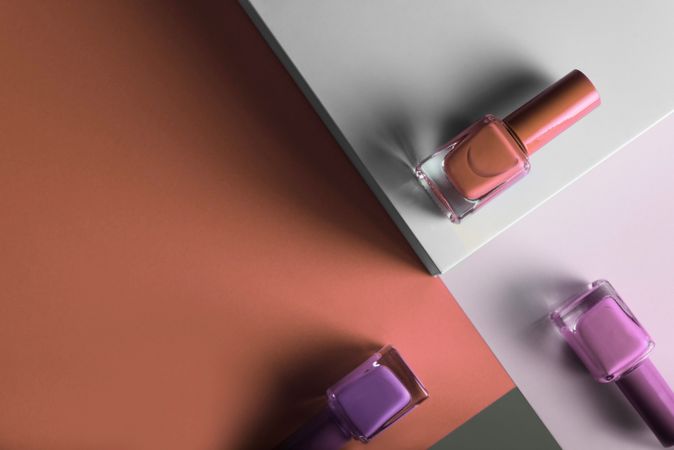 Multi-colored nail polish on pastel colors geometric pattern background