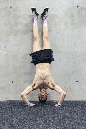 Man doing handstand in gym