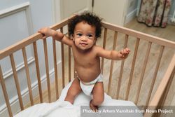 Cute toddler in diaper in crib 0WZl1b