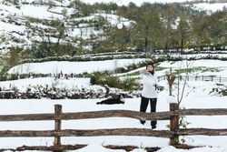 Happy woman play snowballs in countryside
