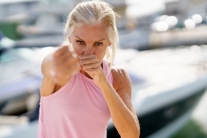 Close up of mature woman practicing boxing on a coastal pier
