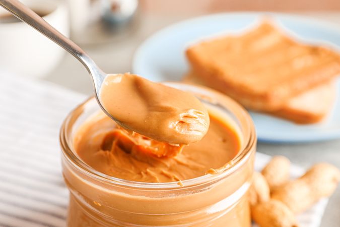 Yummy peanut butter breakfast on grey background, space for text and closeup