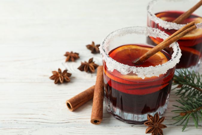 Glasses of tasty mulled wine on wooden background, space for text