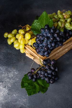 Box of delicious fresh green & red grapes with leaves