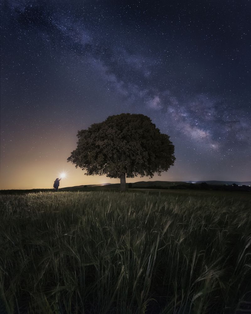 Starry sky and person with ray of light