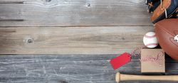 Father’s day gift box with football and baseball items on rustic wooden planks