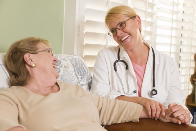 Doctor or Nurse Talking to Sitting Older Woman