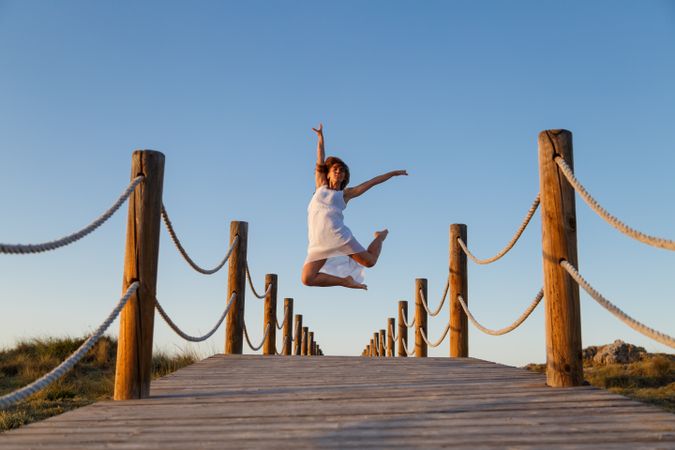 Woman posing in air on footbridge