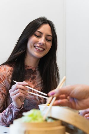 Delighted friendly multiethnic women eating in restaurant