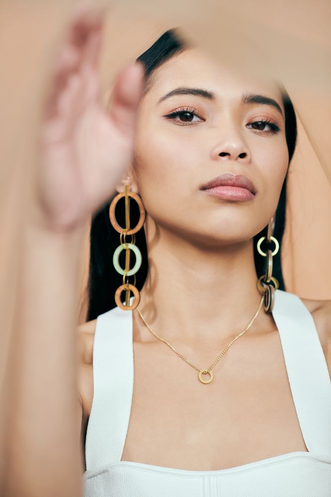 Young woman looking at camera with statement earrings