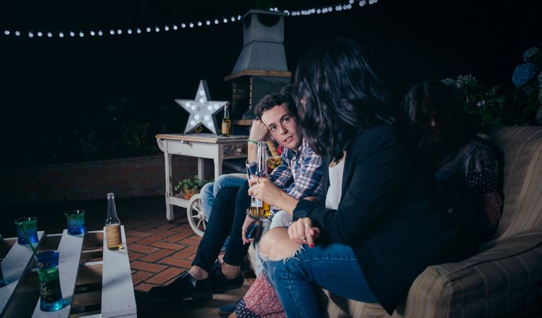 Man talking with female friend holding beer in a party