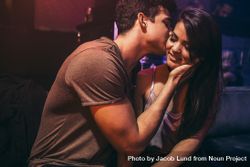 Man kissing girlfriend sitting at lounge bar bD2ar5