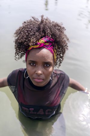 Portrait of a young Black woman with pink headband in the water