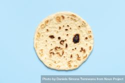 Naan bread isolated on a blue background 0PXDr0