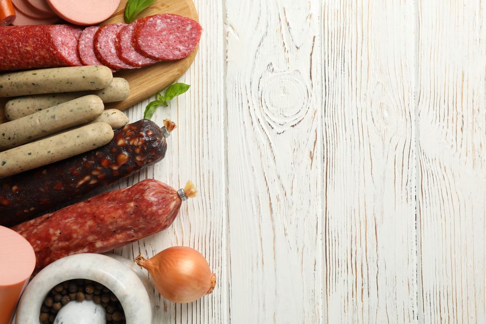 Selection of cured meats with wooden background, copy space
