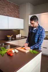 Man chopping carrots in kitchen