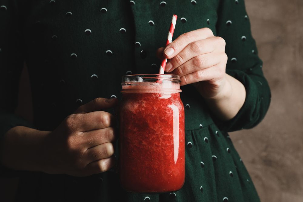 Woman hold glass jar of strawberry cocktail, close up. Summer drink