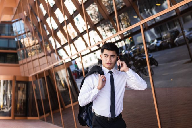 Smiling businessman speaking on smartphone in downtown