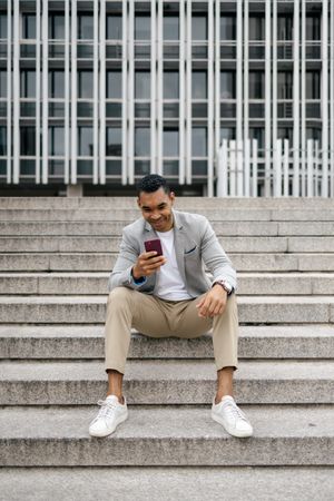 Man sitting on stairs using smartphone