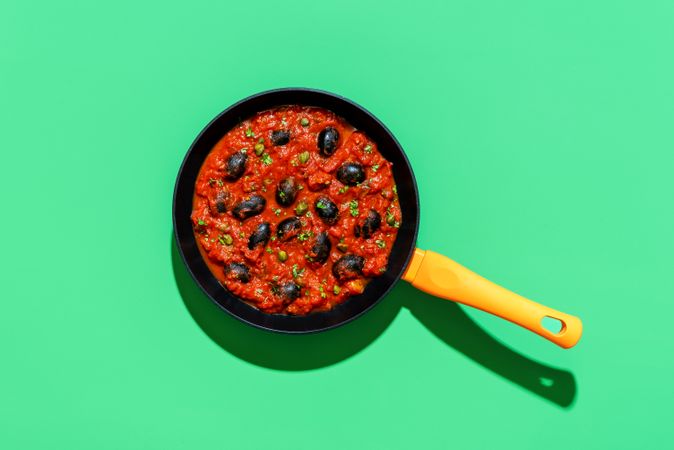 Pasta tomato sauce, italian recipe, above view on a green background