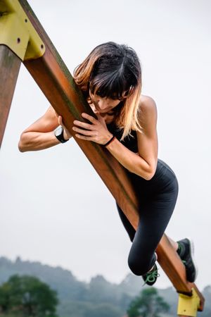 Sportswoman training grabbed to a wooden bar