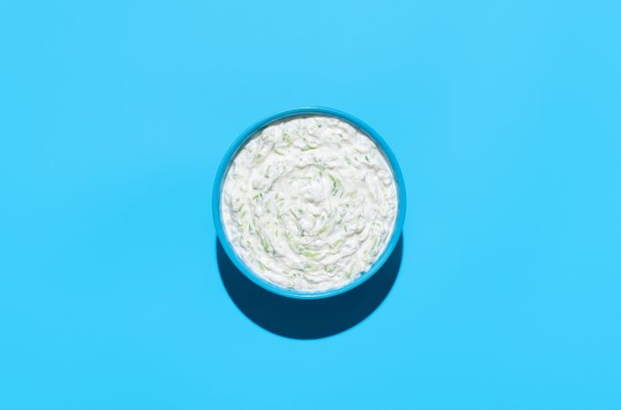 Tzatziki sauce bowl top view on a blue background