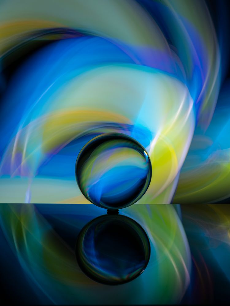 Crystal ball on board near abstract shines