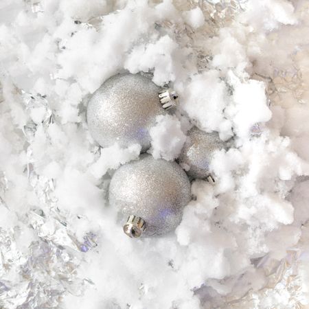 Silver Christmas baubles on snowy background