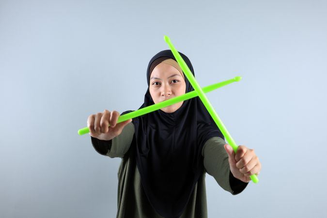 Female Muslim doing Poundfit Rockstar Workout with Green Stick