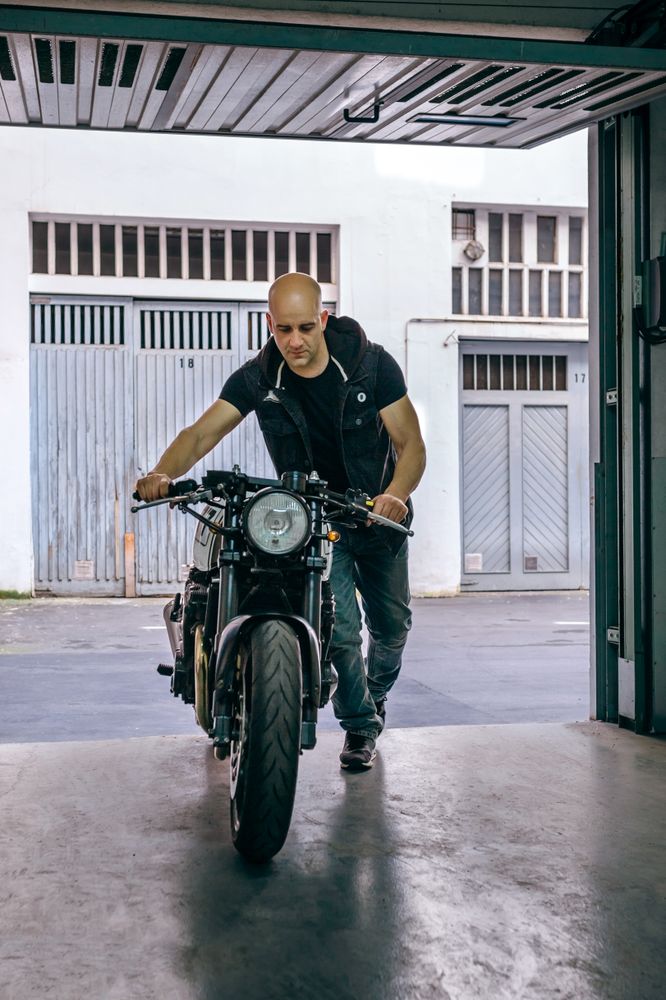 Biker taking motorbike to the garage
