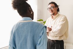 An Asian man and Black woman talking and taking a break in a office setting