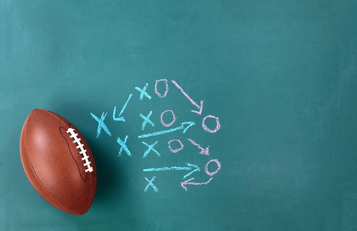 American Football with game plan on green chalkboard  background