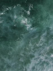 Top view of surfer in dark blue ocean water