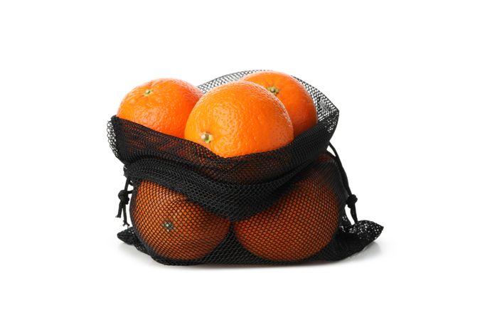 String bag with ripe mandarins isolated on light background
