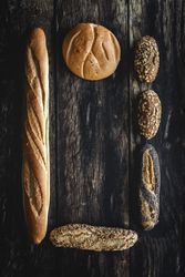 Assorted gold homemade bread on dark wood background