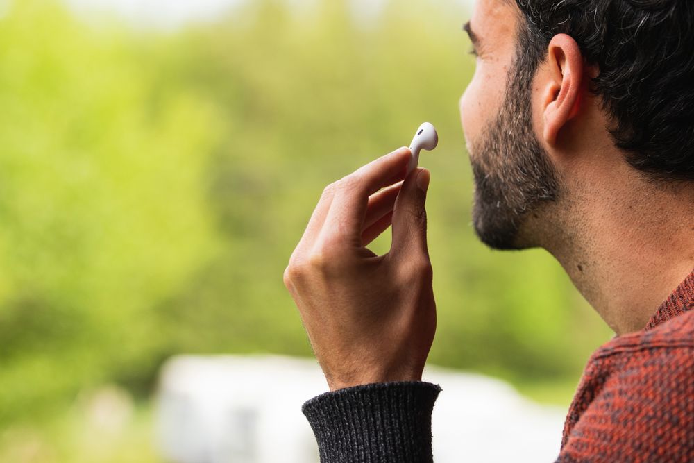 Anonymous man with earbuds against green background