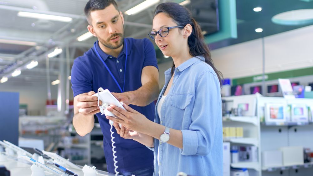 In the Electronics Store Consultant Gives Professional Advice to a Young Woman, She Considers Buying New Tablet Computer