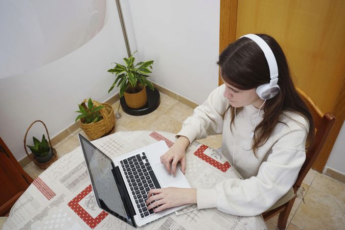 Top view of teenage girl studying online at home