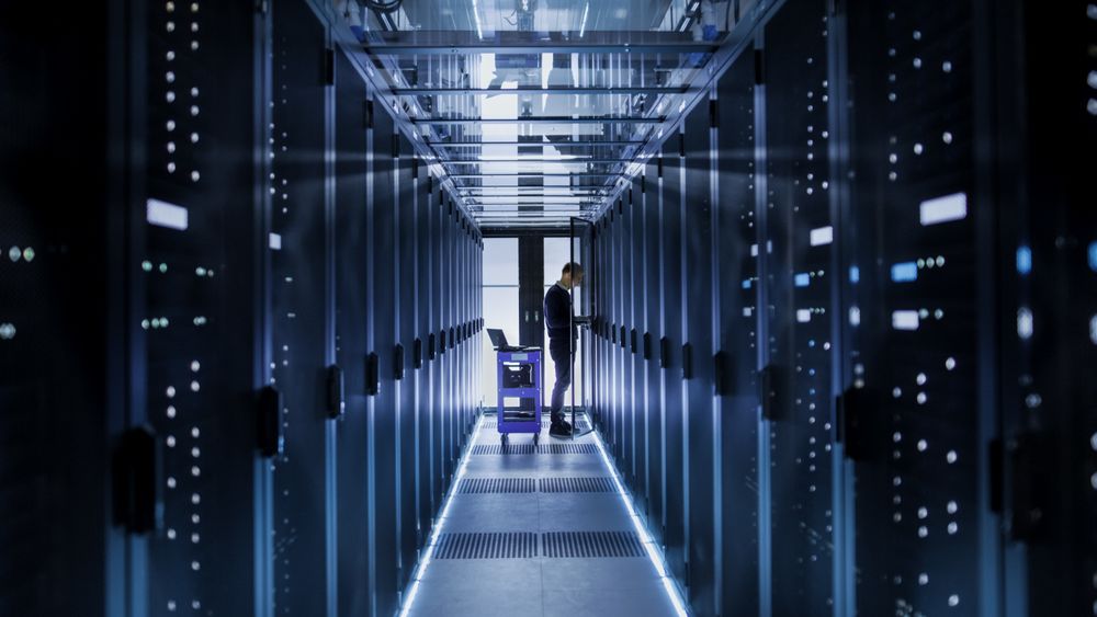 IT Engineer With Crash Cart Puts Hard Drives into Open Rack Server Cabinet.