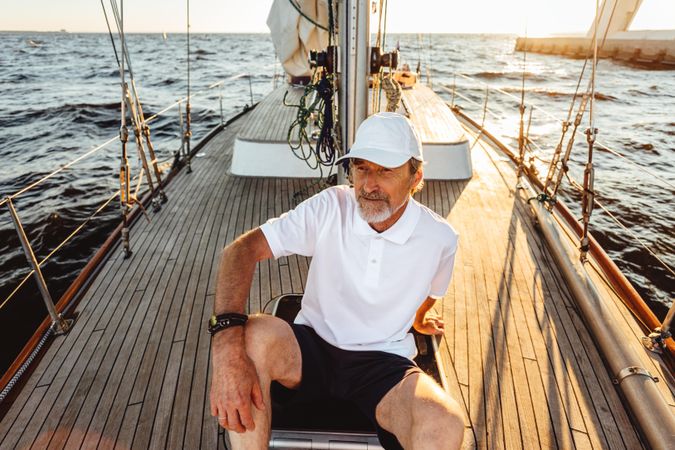 Mature captain sitting on sailboat