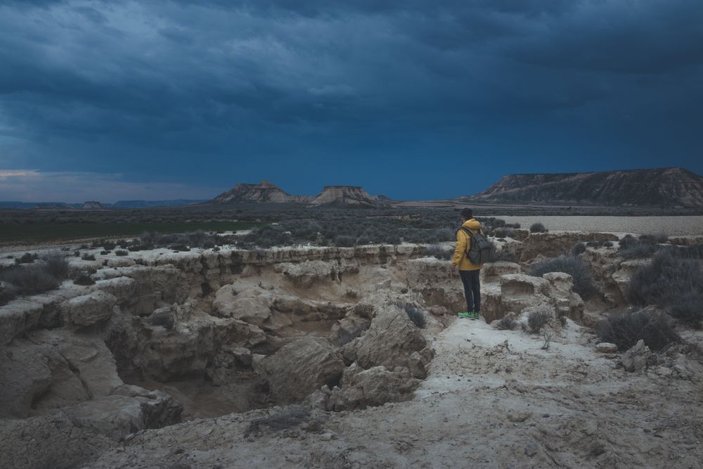Man standing on stone in desert hills