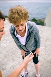 Mature woman looking smart watch with her coach