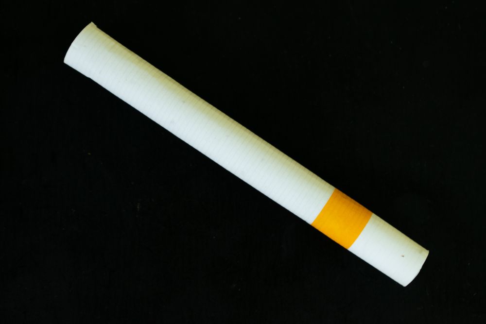 Cigarette laying diagnolly on dark background