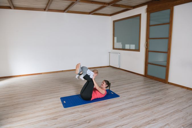 Mother exercising with baby in gym