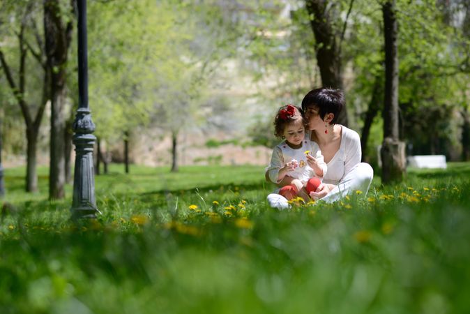 Mother sitting with daughter in park