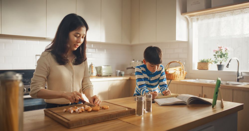 Portrait of Korean Woman Cutting Sausages in her Kitchen at Home.