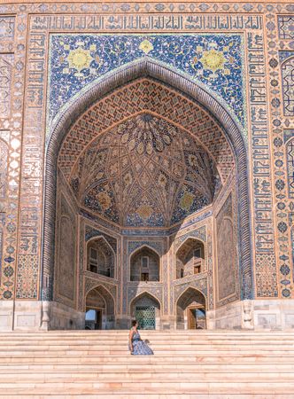 Woman sitting outside ancient building